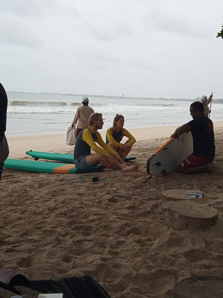 Students relaxing on the sand after a session