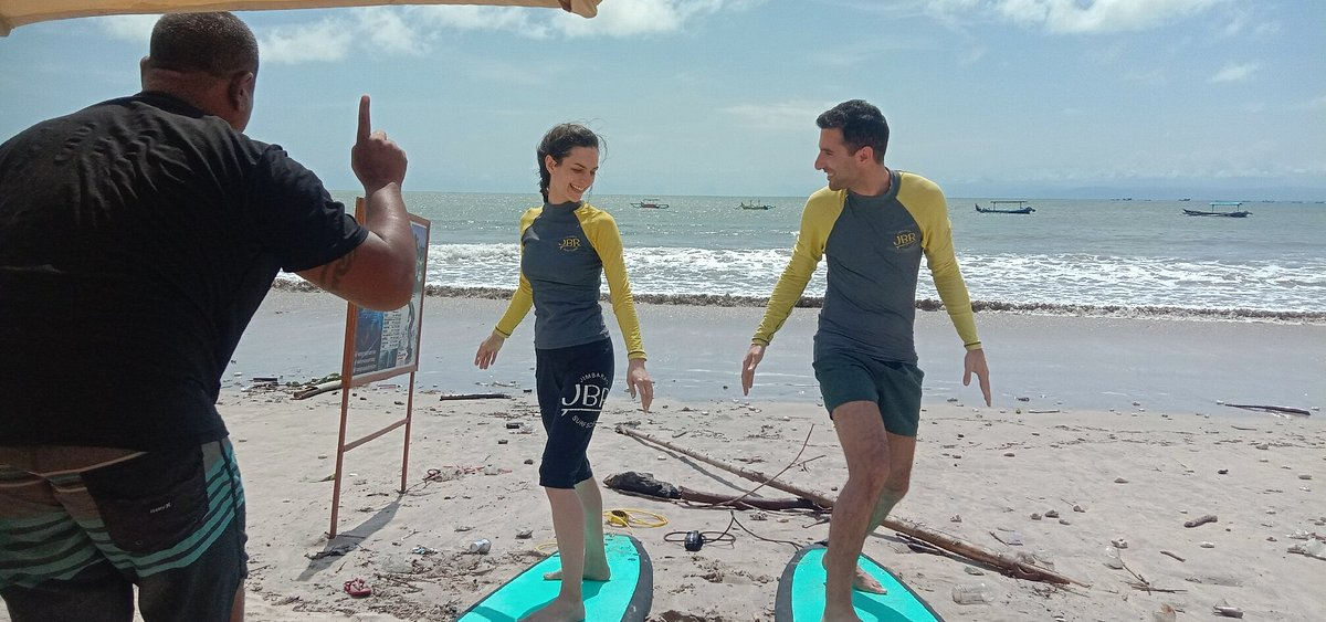Couple practicing the pop-up on the beach