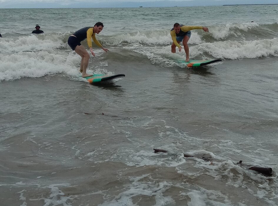 Two students riding a wave at Jimbaran